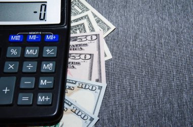 Hesap makinesi, defter, para ve alarm saati ahşap masada, yakın plan..