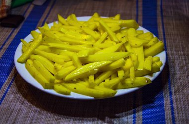 Patates kızartması, beyaz tabakta patates cipsi. Üst Manzara. Mikrodalga fırında pişirilmiş.