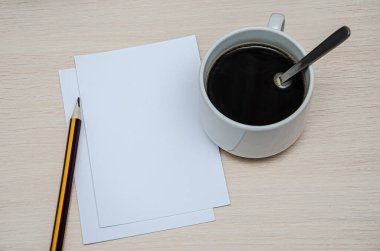 Kitap, kalem ve kahve fincanı ahşap arka planda. Tepkili tasarım modeli.