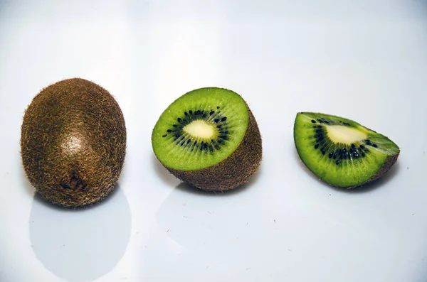 Slices of gold kiwi on glass plate white background
