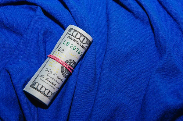 100 Долларовые Купюры Скрученные Трубку Изолированную Синем Фоне — стоковое фото