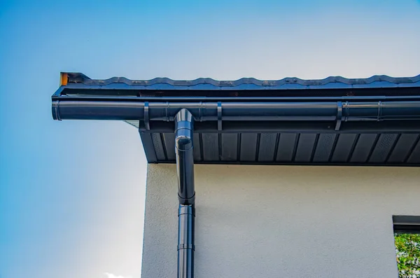 Rännsten med downpipe på taket till ett hus. — Stockfoto