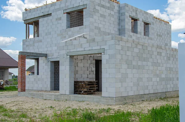 Beyaz köpük bloklardan yapılmış inşaat halindeki bir evin inşaatı. Yeni ev çerçevesi oluşturuluyor.