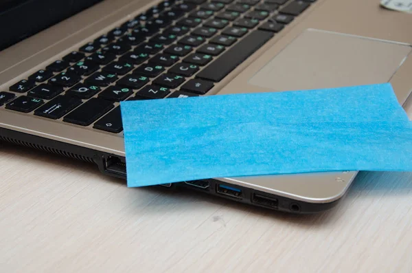 Cropped view of woman cleaning screen of laptop with napkin near notebooks on blurred background on table — Stock Photo, Image