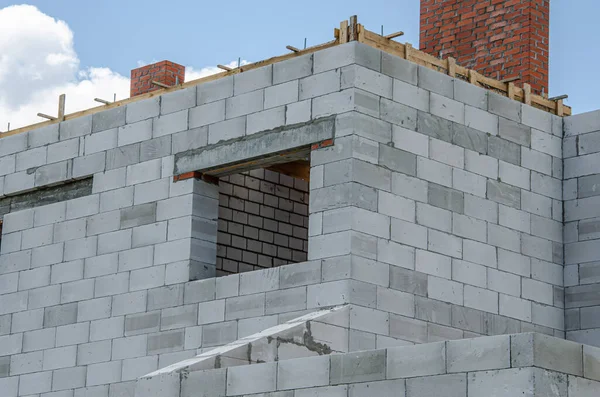 Local de construção de uma casa em construção feita a partir de blocos de concreto de espuma branca. Construção de novo quadro de casa. — Fotografia de Stock