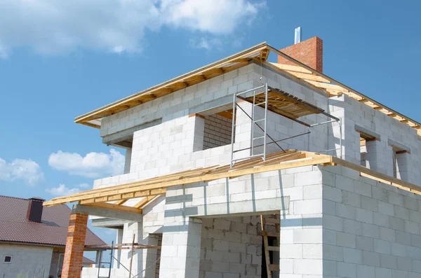 Beyaz köpük beton bloklardan yapılmış inşaat halindeki bir evin inşaatı. Yeni ev çerçevesi oluşturuluyor.