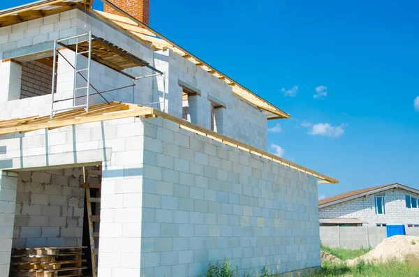Beyaz köpük beton bloklardan yapılmış inşaat halindeki bir evin inşaatı. Yeni ev çerçevesi oluşturuluyor.