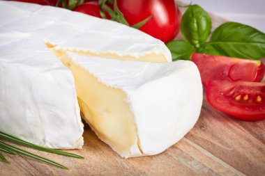 Keçi peyniri, kiraz domates ve otlar bir ahşap tahta üzerinde