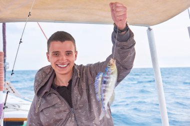 Genç balıkçı tatil günlerinde denizde adam