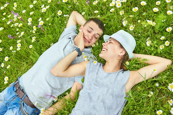 Joyeux jeune couple sur la prairie de camomille — Photo