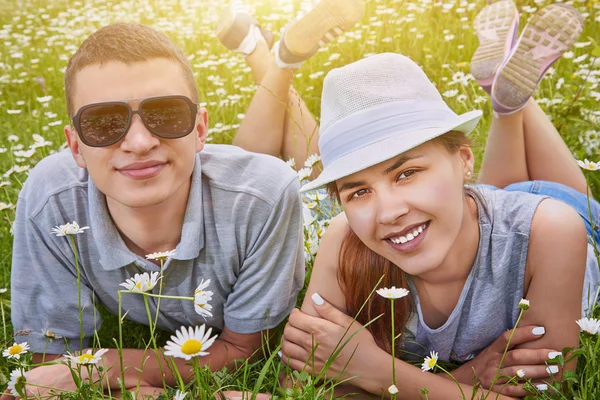 Schönes Paar auf Kamillenwiese liegend — Stockfoto