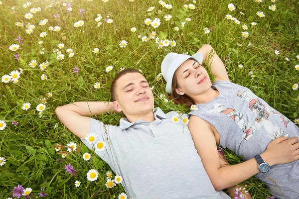 Letecký pohled na šťastný mladý pár v heřmánku louka — Stock fotografie