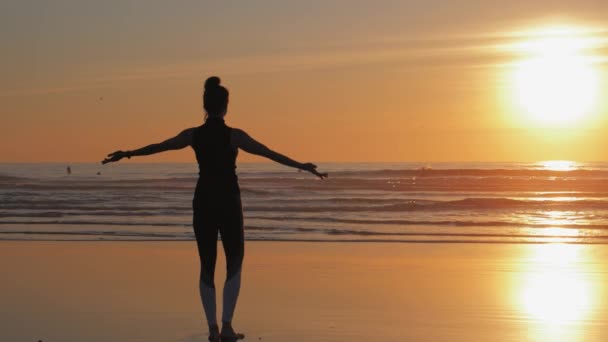 Žena s rukama zvednutýma na pláži, Cvičení jógy — Stock video