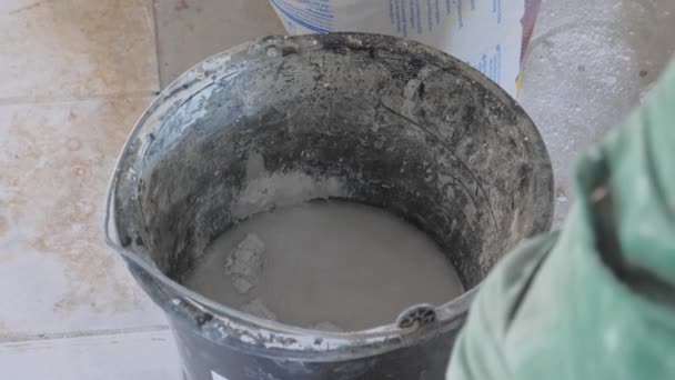 Manusia mencampur semen kering dengan air dalam ember — Stok Video