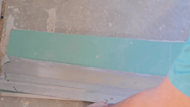 Worker cutting and applying plasterboard material to the wall — Stock Video