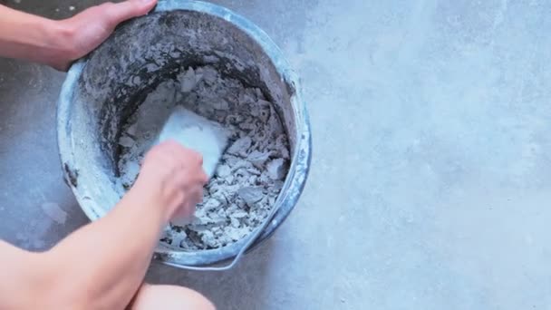 Mann mischt Zement in Eimer — Stockvideo