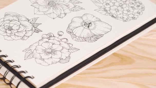 Skład dzikich kwiatów w szkicowniku na stole z ołówkami. — Wideo stockowe