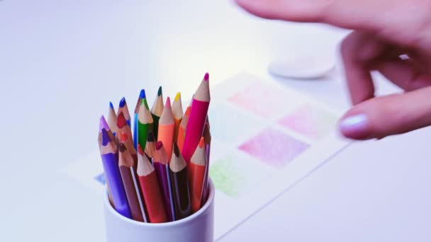 Жіноча рука натискає на олівець у склянці з кольоровими олівцями . — стокове відео