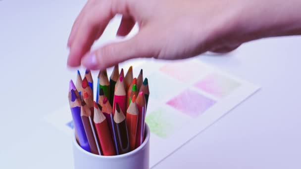 Female hand chooses a pencil in a glass with colored pencils — Stock Video