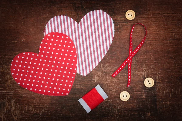 Textile hearts and buttons on old shabby wooden background — Stock Photo, Image