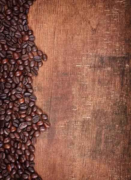 Fundo de madeira com grãos de café nele — Fotografia de Stock