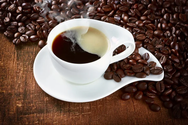 Xícara de café e pires em uma mesa escura de madeira — Fotografia de Stock