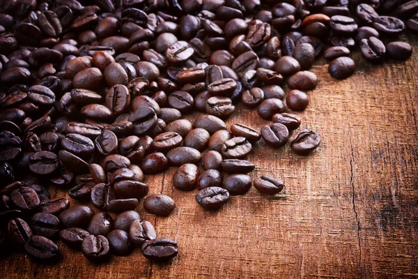 Granos de café sobre fondo de madera — Foto de Stock