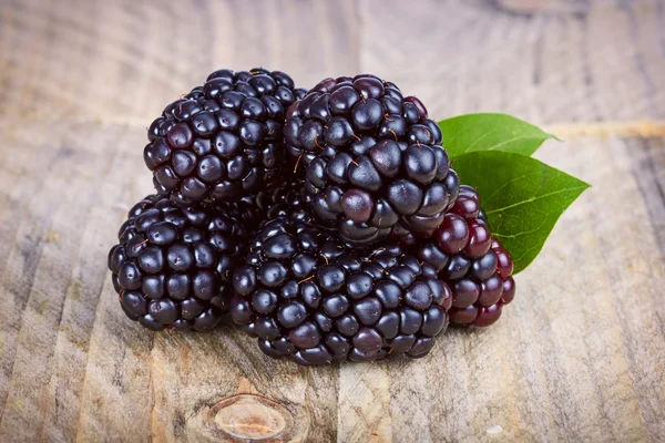 Moras jugosas y maduras sobre fondo de madera — Foto de Stock