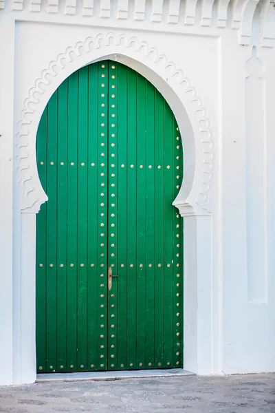 Massive green door in a white wall — Stock Photo, Image