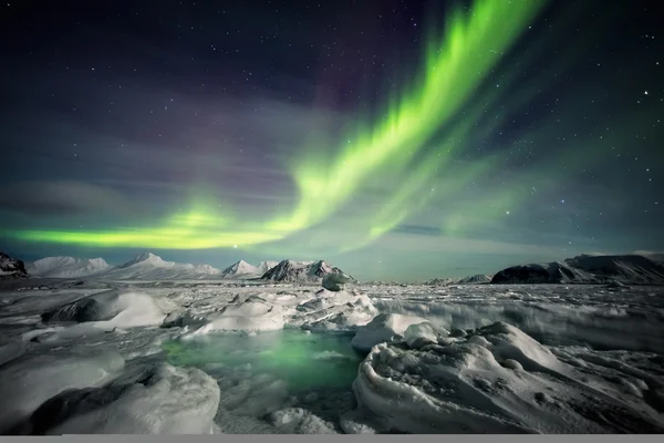 Paisaje inusual del invierno ártico - Fiordo congelado y auroras boreales Fotos de stock