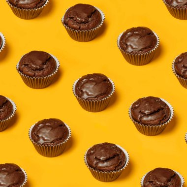 Sarı arka planda çikolatalı kek ya da kurabiye deseni var. Yaz minimalizmi. Isometric düz yatıyordu. Üst Manzara. Yiyecek konsepti.