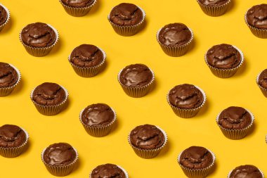 Sarı arka planda çikolatalı kek ya da kurabiye deseni var. Yaz minimalizmi. Isometric düz yatıyordu. Üst Manzara. Yiyecek konsepti.