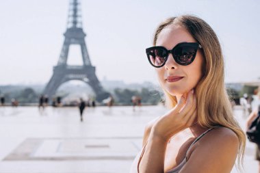Eiffel Kulesi 'ndeki kadın turist. Pembe elbiseli güzel Avrupalı kız Paris, Fransa 'da tatilin tadını çıkarıyor. Seyahat kavramı.