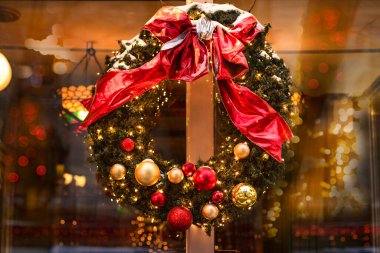 Bayram gecesi kafenin kapısında Noel çelengi. Bulanık ışıkları olan bir sokak kafesinin şenlikli dekoru. Noel ve Yeni Yıl dekorasyonu ve aydınlatma. Noel havası