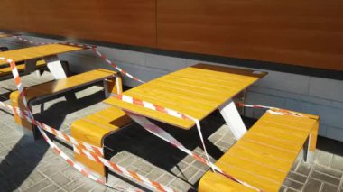 Covid 19 yüzünden karantina sırasında kapalı bir kafede bant sarılı masalar. Kafe ve restoran endüstrisi için zor zamanlar ve kısıtlamalar var. Ziyaretçi ve turistlerden izolasyon ve sosyal uzaklık.