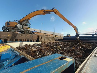 Yakalayıcı yükleme ve boşaltma vinci, geminin ambarından geri dönüşüm için metal ve metal atıkları boşaltır. Ferrous hurdası, demir olmayan hurda. İşleme için hurda ithal ve ihraç et