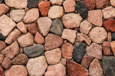 Farklı renklerdeki doğal taşlardan güzel bir arkaplan. Duvarın dekoratif masonluğu çeşitli renklerdeki büyük desenli taşlardan yapılmış. Doğal malzemeler kullanılarak kırsal duvar tasarımı