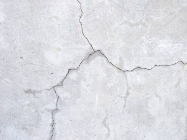 Çatlak duvar dokusu. Arka plan olarak çimento yüzeyi ile kaplı çatlamış beton duvar. Çizik ve çatlaklarla dolu bir duvar parçası.
