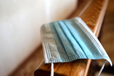 Beyaz arka planda tek kullanımlık tıbbi maske, yakın plan.