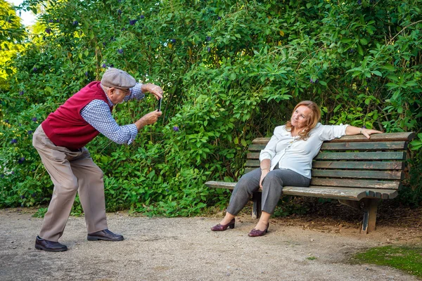 Casal sênior apaixonado tirar fotos em um parque — Fotografia de Stock