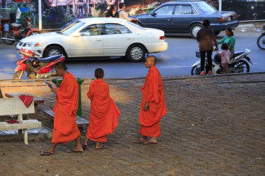 Cambodian monks walking on the street in Kampot clipart
