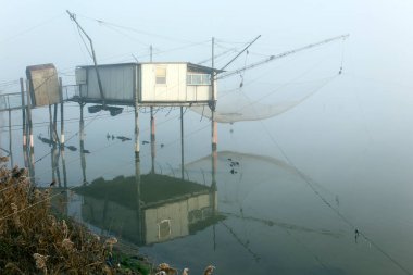 Comacchio, İtalya - 29 Aralık 2019: Sisli bir günde balıkçı evi manzarası