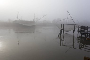 Comacchio, İtalya - 29 Aralık 2019: Sisli bir günde balıkçı evi manzarası