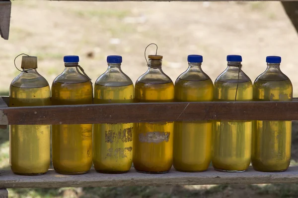 Gasoline for motorbikes sold from whisky bottles by a roadside v — Stock Photo, Image