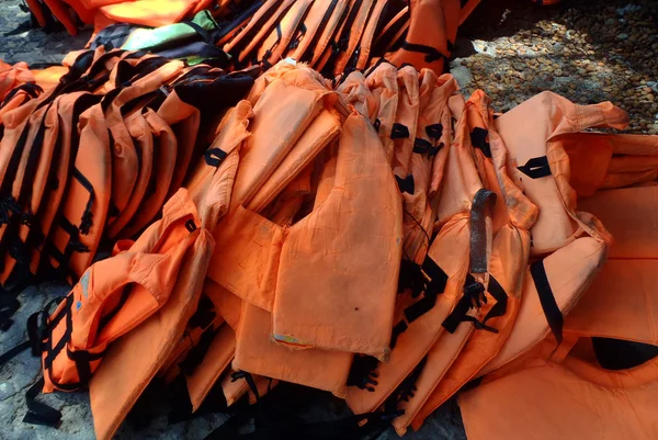 Coletes vermelhos de segurança para esportes marítimos pesam em uma fileira — Fotografia de Stock