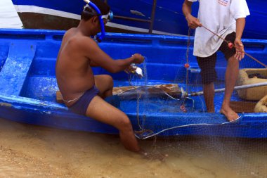 Onun tekne ile balık ağı bir yığın üzerinde duran bir fisher adam