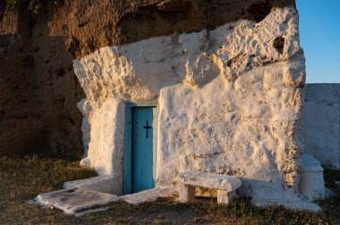 Old chapel built inside a big rock at a beach of Skyros island in Greece at summer clipart