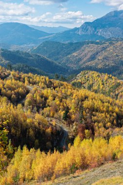 Yunanistan 'ın kuzeybatısındaki Gramos Dağı' nda sonbahar yeşillikleri ve dolambaçlı yollarla manzara