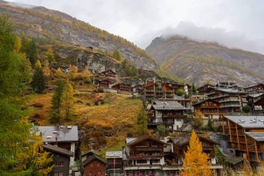 Zermatt, İsviçre-21 Ekim 2019: Sonbaharda ve yağmurlu bir günde Zermatt Bahnhofstrasse Caddesi 'ndeki Eski Bina. Zermatt İsviçre 'de ünlü bir doğa köyüdür..