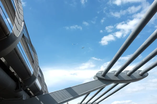 Blauwe hemel en een brug met een kleine vlieger en een vliegtuig in de lucht — Stockfoto